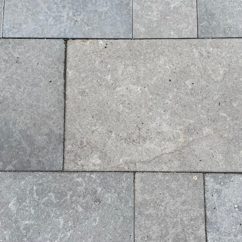 Kalkstein Terrassenplatte Alexandria in bräunlich-grau – Robuste Natursteinfliese mit aufgerauter Oberfläche und getrommelten Kanten für den Außenbereich